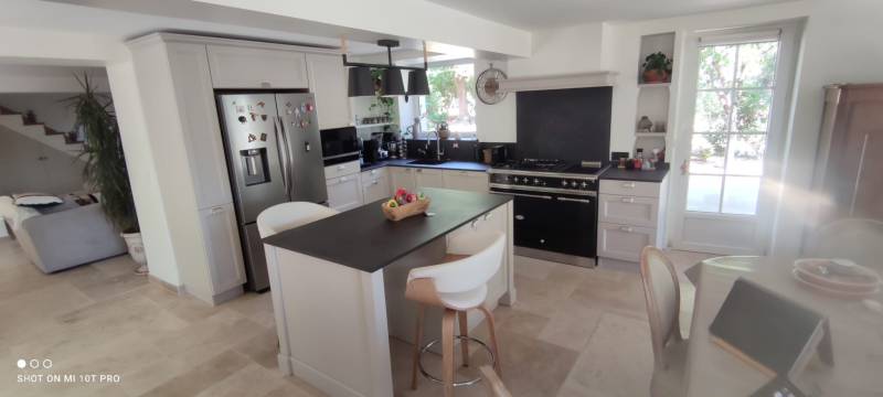 Conception et installation de cuisine classique sur mesure avec aménagement astucieux sous escalier pour optimiser l'espace dans les maisons de village du Vaucluse
