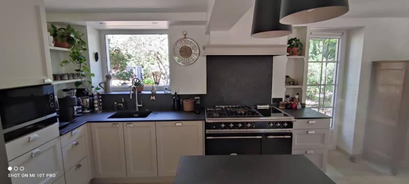 Conception et installation de cuisine classique sur mesure avec aménagement astucieux sous escalier pour optimiser l'espace dans les maisons de village du Vaucluse