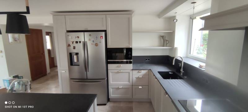 Conception et installation de cuisine classique sur mesure avec aménagement astucieux sous escalier pour optimiser l'espace dans les maisons de village du Vaucluse