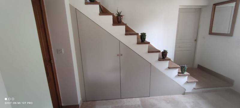 Conception et installation de cuisine classique sur mesure avec aménagement astucieux sous escalier pour optimiser l'espace dans les maisons de village du Vaucluse